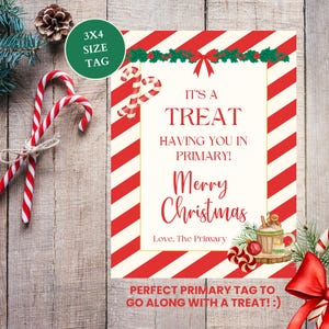 Op de afbeelding: Een rechthoekige kaart met een rood-witte diagonaal gestreepte rand, met de tekst IT'S A TREAT HAVING YOU IN PRIMARY! Merry Christmas Love, The Primary. Het ontwerp bevat illustraties van zuurstokken, hulst en een mok.