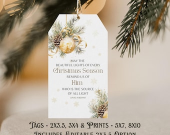 May include: A white Christmas gift tag with gold detailing, featuring a gold bauble, pine needles, and text. The tag reads "May the beautiful lights of every Christmas Season remind us of Him who is the source of all light." Includes editable 2x3.5 option.
