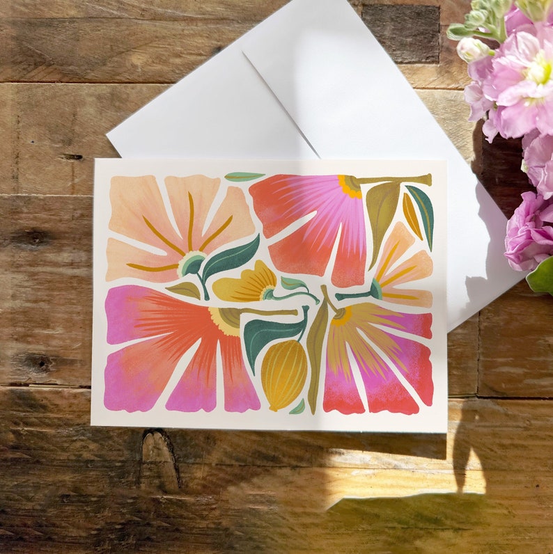 May include: A greeting card with a floral design featuring pink, orange, and yellow flowers. The flowers are stylized and have a modern, abstract look.