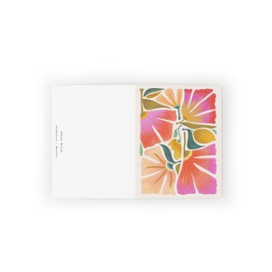 May include: A greeting card with a floral design featuring pink, orange, and green flowers. The card has the text "Dear Wild" printed on the front.