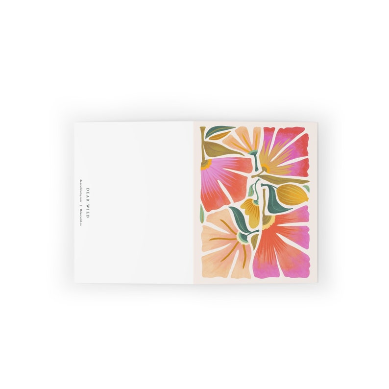 May include: A greeting card with a floral design featuring pink, orange, and green flowers. The card has the text "Dear Wild" printed on the front.