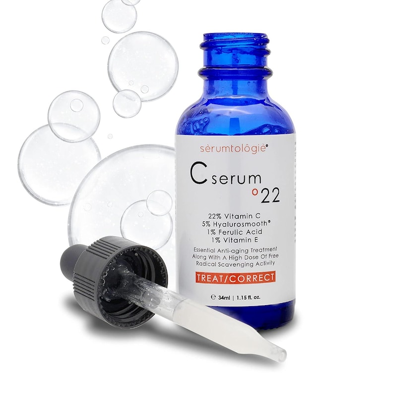 May include: A blue glass serum bottle with a dropper, labeled "C serum 22" with text indicating 22% Vitamin C and other ingredients. The bottle contains 1.15 fl. oz. of product. The label also says "TREAT/CORRECT".