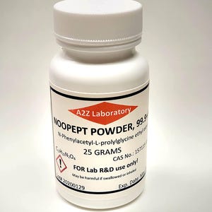 May include: A white plastic bottle with a white cap. The label reads "NOOPEPT POWDER, 99.9%" and "25 GRAMS". The bottle is for lab use only and has a warning symbol. The product is from A2Z Laboratory.