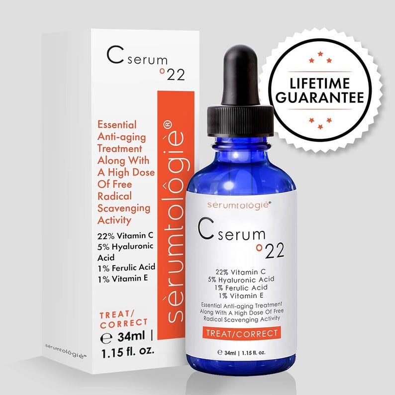 May include: A blue glass serum bottle with a black dropper and a white label, next to a white box. The label reads "C serum 22" and lists ingredients. The box has the same text and an orange stripe. A "Lifetime Guarantee" sticker is visible.