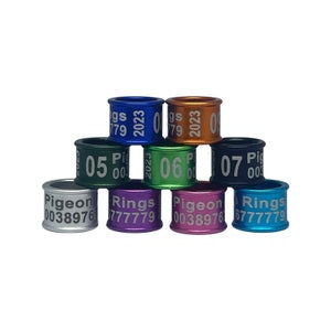 May include: A set of ten colorful metal rings with white lettering. The rings are numbered 05, 06, and 07, and include the year 2023. The rings also have the words "Pigeon" and "Rings" printed on them.