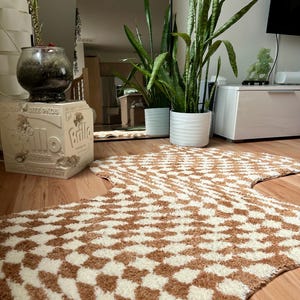 May include: A brown and white patterned rug with a geometric design. The rug is shaped like a large, irregular star. The rug is on a wooden floor.