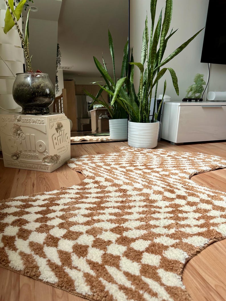 May include: A brown and white patterned rug with a geometric design. The rug is shaped like a large, irregular star. The rug is on a wooden floor.