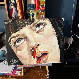 Pode incluir: Uma pintura de um rosto de mulher com o nariz sangrando. A mulher tem cabelo escuro e está olhando para cima. A pintura é assinada "Kitty Smalls".