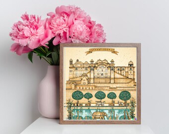 May include: A framed print of a detailed illustration of a palace in a warm yellow color with green trees in front of it. The print is on a textured paper background and has a brown wooden frame.