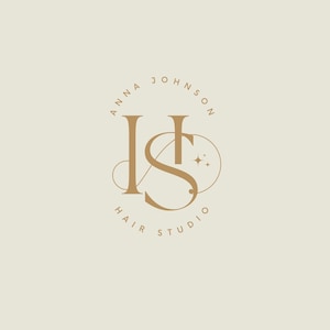 May include: A logo for Anna Johnson Hair Studio, featuring the initials "AJ" in a stylized, elegant design. The letters are in a warm, golden-brown color against a cream background. The words "Anna Johnson" and "Hair Studio" are in a circular arrangement.