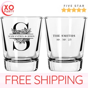 May include: Two clear glass shot glasses with personalized text. The first glass has a floral design with the letter "S" and the text "Samantha & John". The second glass has the text "The Smiths 10 | 30 | 25".