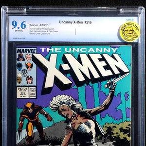Puede incluir: Una portada de cómic con los X-Men. El arte de la portada muestra a Tormenta, una superheroína con cabello blanco y piel azul, sosteniendo una espada y de pie sobre un hombre con un traje rojo. El cómic se titula "The Uncanny X-Men" y es el número 216.