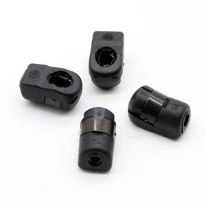 May include: Four black plastic end caps with different sizes and markings. The end caps have a round shape with a hole in the center.
