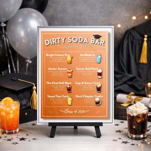 以下が含まれることがあります： 卒業を祝うテーマの、黒いイーゼルに立てられた「Dirty Soda Bar」の額入り看板。看板には、「Bright Future Fizz」や「Cap & Gown Twist」などの名前のソーダベースのドリンクメニューが掲載されています。背景には風船と卒業式の装飾があります。
