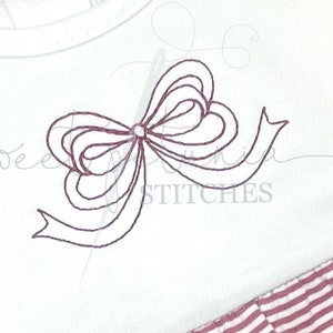 以下が含まれることがあります： 白いベビーボディスーツ、バーガンディ色の刺繍リボンデザイン。上部に「VINTAGE STITCH LOOPY BOW」、下部に「FONT NOT INCLUDED」と「STITCHED BY @STACYS_SOUTHERN_STYLES」の文字。ボディスーツにはストライプのフリルが付いています。