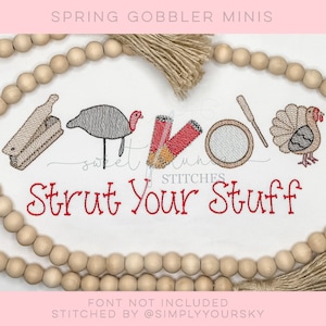 Puede incluir: Diseño bordado con un pavo, un tambor, un rodillo y una cornucopia. El texto "Strut Your Stuff" está bordado en rojo. El diseño está rodeado por una guirnalda de cuentas de madera.