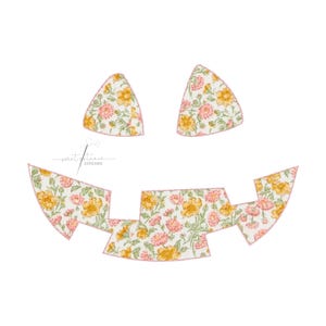 May include: Floral fabric cutouts in the shape of a jack-o'-lantern face. The fabric features a white background with yellow and pink flowers. The edges are outlined in pink. The text "sweet petunia stitches" is in the lower left corner.