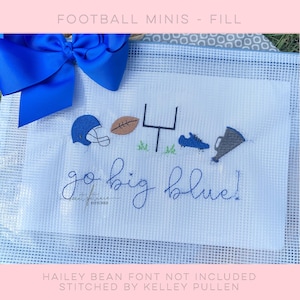 May include: White fabric with blue embroidered football-themed designs, including a helmet, football, goalpost, shoe, and megaphone. The phrase "go big blue!" is written in cursive. A large blue bow is in the upper left corner.