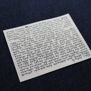 Pu&ograve; includere: Primo piano di un pezzo di carta bianco con testo ebraico nero. Il testo &egrave; scritto in uno script tradizionale e include le parole "לאוח על" e "בכל לבב".