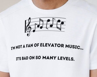 Puede incluir: Camiseta blanca con un gráfico de nota musical negra y el texto "I'M NOT A FAN OF ELEVATOR MUSIC... IT'S BAD ON SO MANY LEVELS."