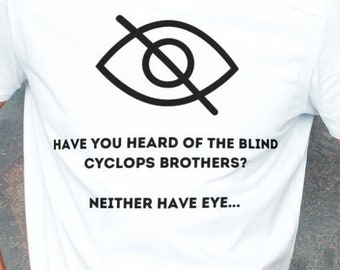 Puede incluir: Camiseta blanca con un ojo negro tachado y el texto "HAVE YOU HEARD OF THE BLIND CYCLOPS BROTHERS? NEITHER HAVE EYE..."