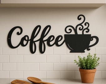 Może przedstawiać: Czarna metalowa grafika ścienna z napisem "Coffee" i wzorem filiżanki do kawy. Słowo "Coffee" jest napisane kursywą. Z filiżanki do kawy unosi się para. Grafika jest zamontowana na białej kafelkowej ścianie.