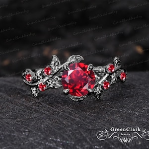 May include: A white ceramic mug with a black handle and the text "But First, Coffee" in a bold, black font. The mug is filled with a dark liquid, probably coffee, and rests on a light-coloured surface.