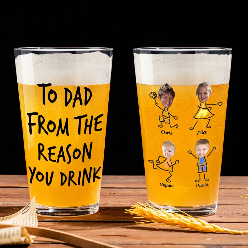 May include: Two clear glass beer mugs with a yellow beverage. One mug has the text "To Dad From The Reason You Drink". The other mug has stick figure drawings of children with their faces in the drawings. The children's names are written below their drawings.