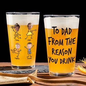 May include: Two clear glass beer mugs. One mug has a drawing of a family with the text "To Dad From The Reason You Drink". The other mug has drawings of four children with their names written below each drawing.
