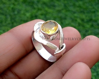 Könnte beinhalten: Ein silberner Ring mit einem großen, ovalen, gelben Edelstein. Der Ring hat ein einzigartiges, wirbelndes Design um den Stein herum. Der Text "OMJEWELRYCRAFTS" ist auf der Seite des Rings zu sehen.