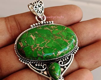 May include: A silver pendant with a green and gold turquoise stone. The pendant has intricate silver detailing and a bail for attaching a chain.