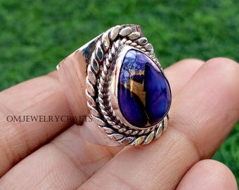 Könnte beinhalten: Ein Silberring mit einem großen, tropfenförmigen, tiefblauen Stein mit Goldsprenkeln. Der Stein ist in einer dekorativen Lünette mit einem geflochtenen Seildesign gefasst. Der Ring befindet sich auf einer Hand, mit dem Text "OMJEWELRYCRAFTS" sichtbar.