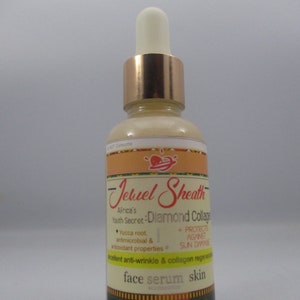 May include: A glass bottle of face serum with a gold cap and a label that reads "Jeruel Sheath Africa's Youth Secret: Diamond Collage". The label also lists the ingredients "Yucca root, antimicrobial & antioxidant properties" and "Protects against sun damage". The bottle is labeled "face serum skin".