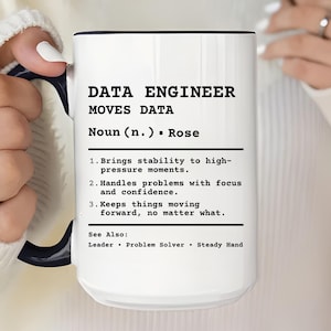 May include: White ceramic mug with a black interior and handle. The mug features the text "DATA ENGINEER MOVES DATA" with a definition. The definition includes the words "stability", "focus", and "confidence".