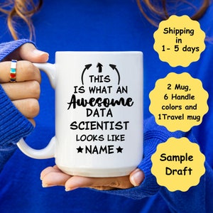 May include: White ceramic mug with the text "THIS IS WHAT AN Awesome DATA SCIENTIST LOOKS LIKE ★NAME★" in black. The mug has a large handle and is held by a person wearing a blue sweater. The mug is a gift for data scientists.