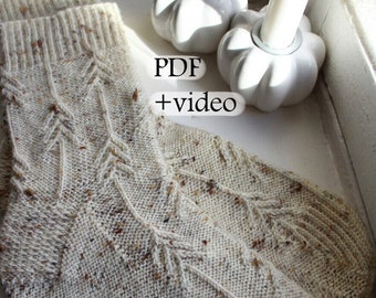 Peut inclure: Une paire de chaussettes tricotées de couleur crème avec un motif de points marrons. Les chaussettes présentent un motif de tricot en câble avec un motif répétitif de lignes verticales. Le texte "PDF + vidéo" est visible sur l'image.