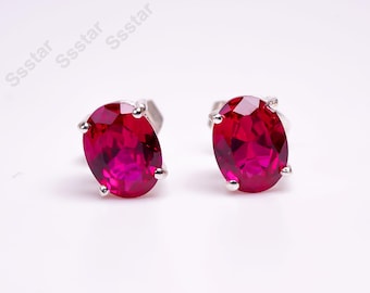 Peut inclure: Une paire de boucles d'oreilles en argent avec des pierres précieuses rouges de forme ovale.