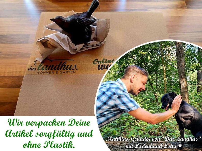 May include: A black cast iron bird figurine resting on crumpled brown paper atop a cardboard box labelled das landhus WOHNEN & GARTEN. A circular inset shows a person in a blue plaid shirt petting a black dog in a forest with text below.