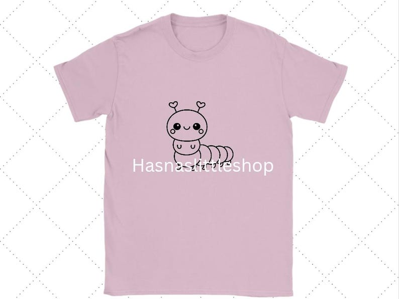 May include: A light pink t-shirt featuring a cute cartoon caterpillar with heart-shaped antennae. The caterpillar is drawn in black and has a smiling face. The text "Hasnaskittleshop" is printed below the caterpillar.