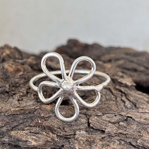 Peut inclure: Une bague en argent avec un motif de fleur délicat. La bague est en argent sterling et a un style simple et élégant.