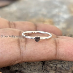 Puede incluir: Un anillo de plata sencillo con un pequeño diseño en forma de corazón.