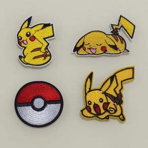 以下が含まれることがあります： ポケモンのキャラクター、ピカチュウが描かれたアイロン接着式の刺繍パッチが4つ。1つのパッチはピカチュウが立っている様子、もう1つはピカチュウが寝転んでいる様子、2つのパッチはピカチュウが走っている様子を表しています。4つ目のパッチは赤と白のモンスターボールです。