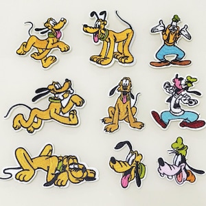 Op de afbeelding: Tien geborduurde strijkpatches met cartoonhonden. De patches zijn in verschillende poses en hebben verschillende kleuren, waaronder geel, bruin, zwart, wit, rood en blauw.