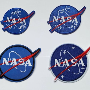 Puede incluir: Cuatro parches bordados de la NASA con fondo azul, letras blancas y una línea curva roja. Los parches están sobre un fondo blanco.