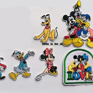 Może przedstawiać: Zestaw 7 haftowanych naszywek do prasowania z różnymi postaciami Disneya, w tym Myszka Miki, Minnie Mouse, Kaczor Donald, Goofy, Pluto i zdjęcie grupowe Mickey, Donalda i Goofy. Naszywki są kolorowe i przedstawiają różne pozy i wyrażenia twarzy.