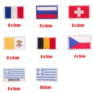 Puede incluir: Nueve parches bordados para planchar con banderas de diferentes países. Las banderas miden 8 por 5 centímetros y se muestran sobre un fondo blanco.