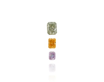 May include: Three rectangular-cut gemstones in a vertical arrangement. The top gem is a light green, the middle is orange, and the bottom is a light purple. Each gem has a reflective surface, with a white background.
