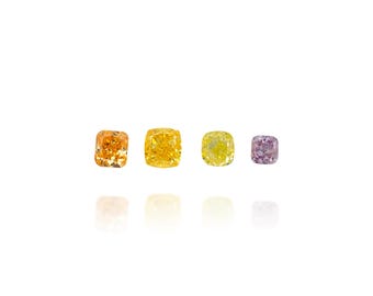 Puede incluir: Cuatro gemas de talla cojín en tonos naranja, amarillo y morado se muestran sobre un fondo blanco. Las gemas están dispuestas en fila, cada una reflejando la luz y mostrando su color y claridad únicos. Las gemas son de diferentes tamaños.