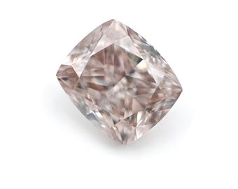 May include: A cushion-cut diamond with a soft pink hue. The gemstone has multiple facets that reflect light, creating a sparkling effect. The diamond is set against a white background, highlighting its color and clarity.