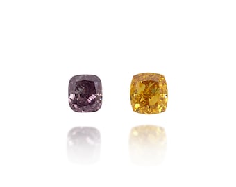 May include: Two cushion-cut diamonds, one a deep purple hue and the other a vibrant yellow. The gems are set against a white background, with their reflections visible below. The diamonds are likely for jewelry.